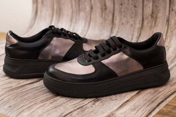 istock Sneaker in eco-leather, black and gold, inverted profile view 2173790851