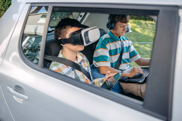 istock Teenagers sitting on back seat of car using digital tablet while sitting on back seat before going to school 2173801117