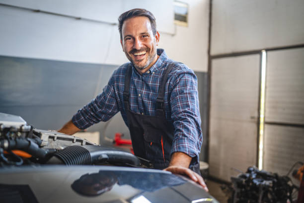 istock Car mechanic smile and stand next to car engine in workshop setting 2173808675