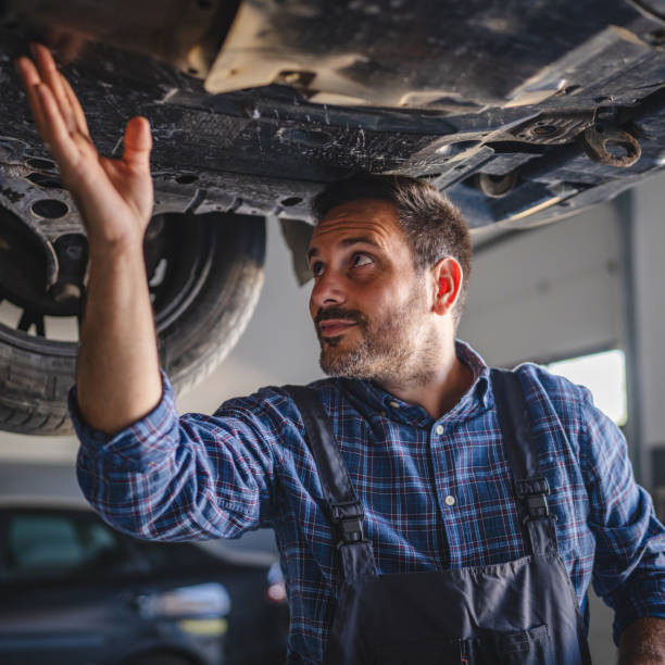 Car mechanic hold part of automobile undercarriage system