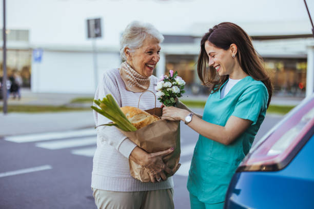 istock Friendly Nurse Assisting Elderly Woman with Groceries 2173809291