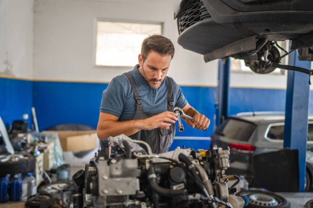 istock Car mechanic in navy overalls working on car engine with tools 2173809462