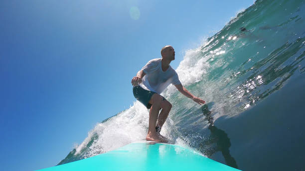 istock Man surfing a glassy wave on a blue board 2173810813