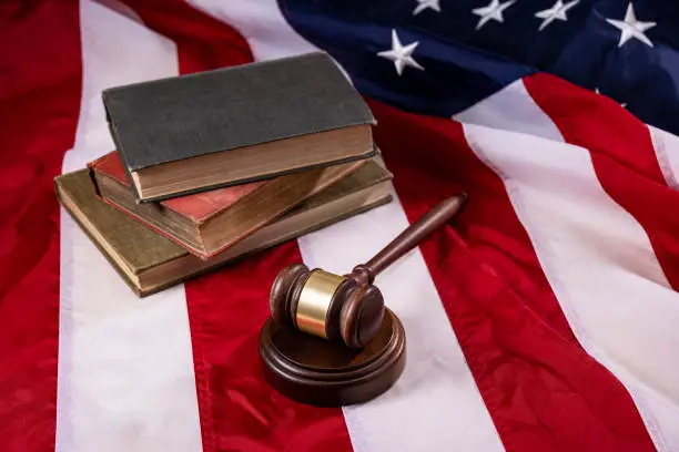 Courtroom Gavel and stack of books on an American Flag Courtroom Gavel and stack of books on an American Flag