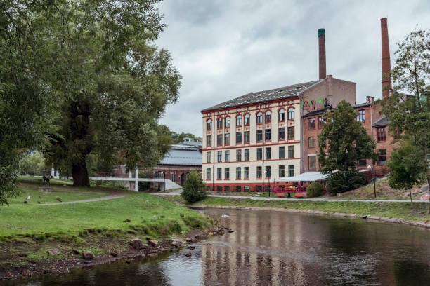istock Modern Mixed-Use Building Along the Canal in Oslo, Norway, Featuring Lush Greenery and Reflections in the Water on a Cloudy Spring Day 2173814697