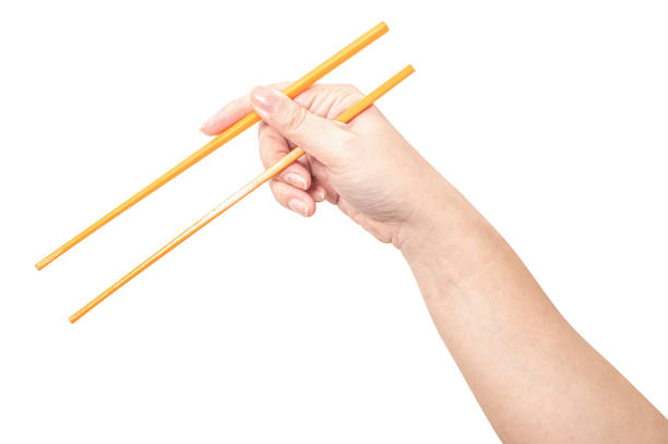 istock Female hand holding a orange plastic chopstick isolated on white background. 2173821558