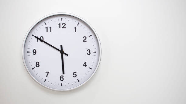 Minimalist White Clock with Silver Frame Striking 17.50/05.50 on White Background  Perfect for Time Management and Corporate Campaigns