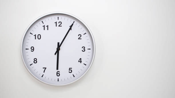istock Minimalist White Clock with Silver Frame Striking 18.05/06.05 on White Background  Perfect for Time Management and Corporate Campaigns 2173833506