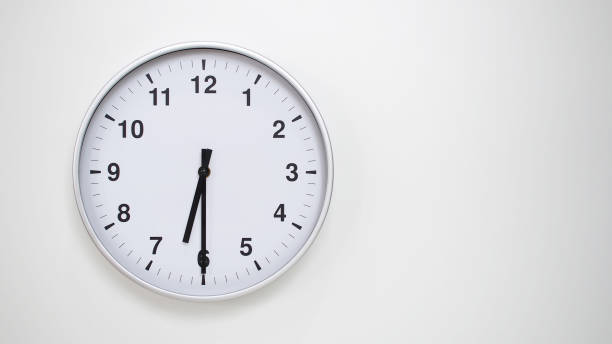istock Minimalist White Clock with Silver Frame Striking 18.30/06.30 on White Background  Perfect for Time Management and Corporate Campaigns 2173833514