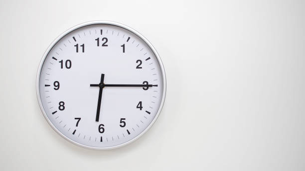 istock Minimalist White Clock with Silver Frame Striking 18.15/06.15 on White Background  Perfect for Time Management and Corporate Campaigns 2173833519