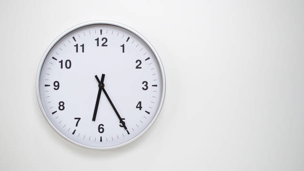 istock Minimalist White Clock with Silver Frame Striking 18.25/06.25 on White Background  Perfect for Time Management and Corporate Campaigns 2173833520