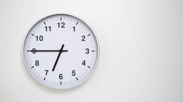 istock Minimalist White Clock with Silver Frame Striking 18.45/06.45 on White Background  Perfect for Time Management and Corporate Campaigns 2173833536