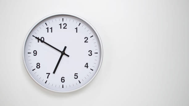 istock Minimalist White Clock with Silver Frame Striking 18.50/06.50 on White Background  Perfect for Time Management and Corporate Campaigns 2173833538