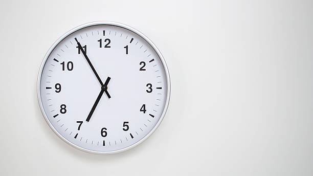 istock Minimalist White Clock with Silver Frame Striking 18.55/06.55 on White Background  Perfect for Time Management and Corporate Campaigns 2173833542