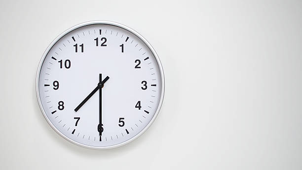 istock Minimalist White Clock with Silver Frame Striking 19.30/07.30 on White Background  Perfect for Time Management and Corporate Campaigns 2173833564