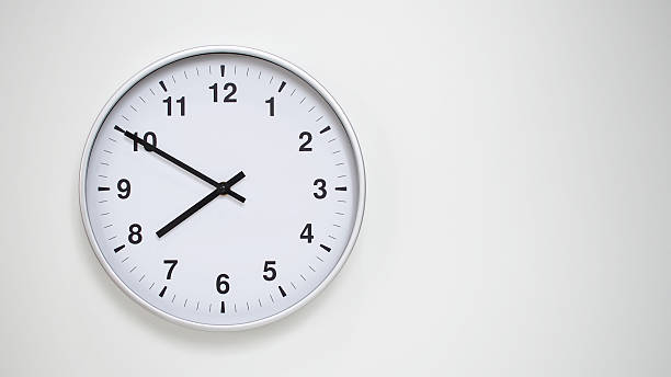 istock Minimalist White Clock with Silver Frame Striking 19.50/07.50 on White Background  Perfect for Time Management and Corporate Campaigns 2173833567