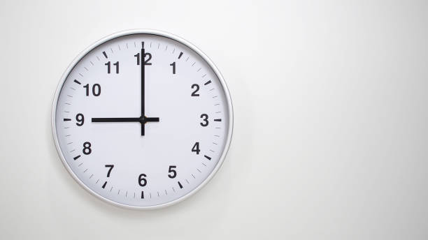 istock Minimalist White Clock with Silver Frame Striking 21.00/09.00 on White Background  Perfect for Time Management and Corporate Campaigns 2173833618
