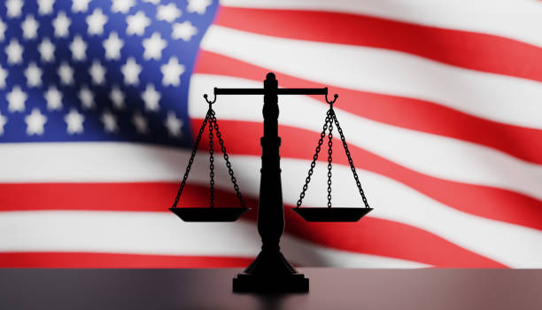 istock Justice scale in silhouette in front of an American flag 2173838883