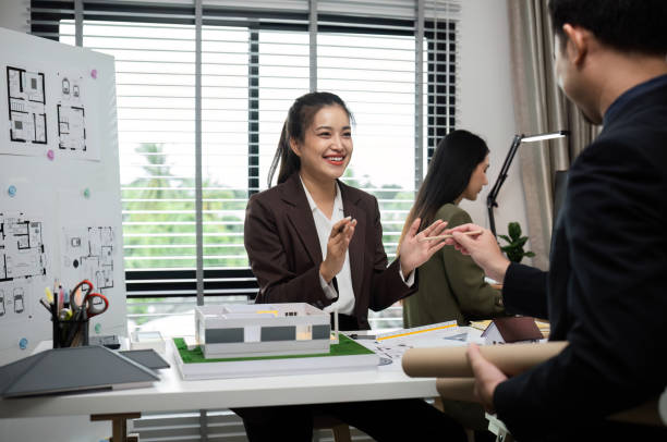 istock Business Team Discussing Real Estate Project with Architectural Plans and Model in Modern Office Setting 2173849250