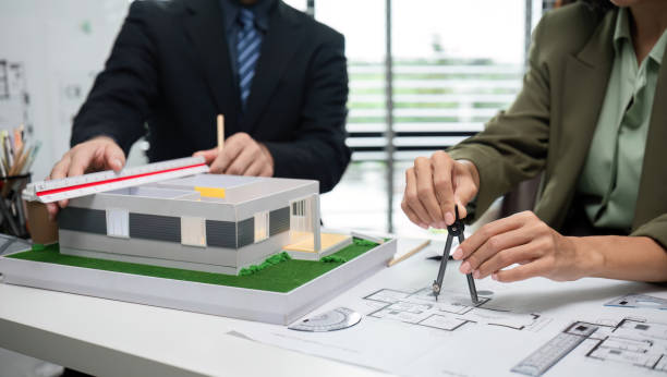 istock Businessmen Collaborating on Real Estate Project with Architectural Model and Blueprints in Modern Office 2173849333