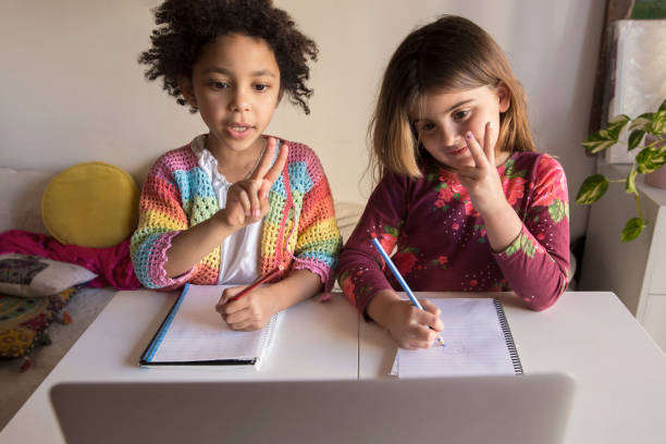 istock Two children engaged in a virtual learning activity while sitting at a desk at home. 2173852397