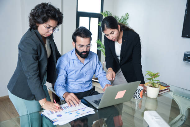 istock Young indian businessman with his employees working together on company project while using laptop and analyzing reports. financial planning and strategy concept. 2173859457