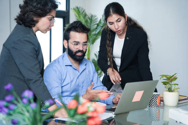 istock Young indian businessman with his employees working together on company project while using laptop. financial planning and strategy concept. 2173859470
