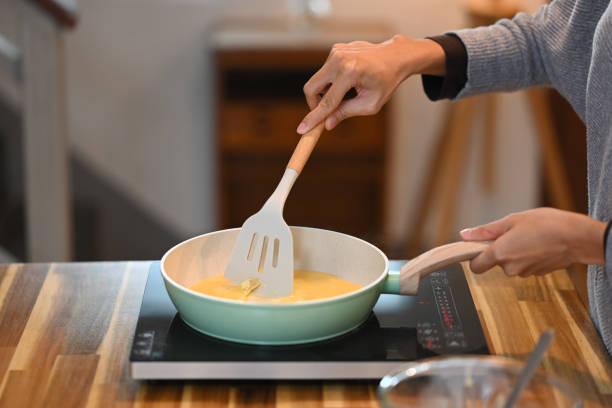 istock Cropped shot of young woman making simple scrambled egg for breakfast 2173861010