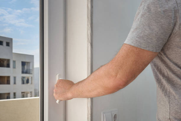 istock A man closes a plastic window in a city apartment. 2173867266