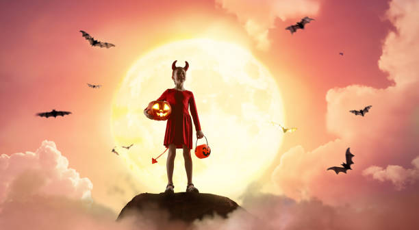 istock girl in devil costume at Halloween 2173884671