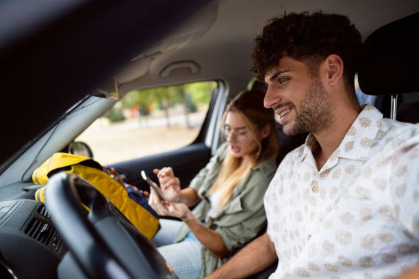 istock Girlfriend using mobile phone and GPS app to navigate, while her boyfriend driving the car 2173885380