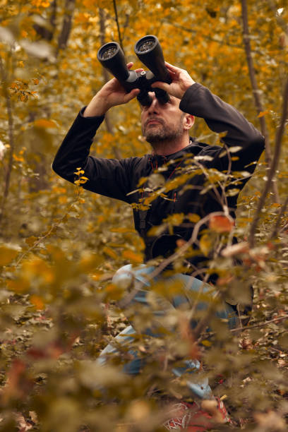 istock Man using binoculars for birdwatching and other observing animals in nature. 2173888130