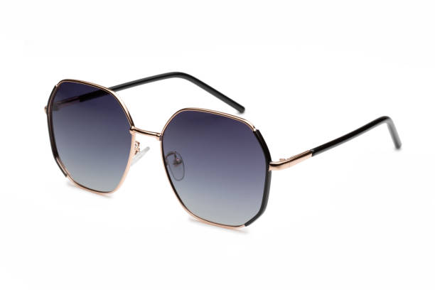 istock Black and gold sunglasses with a unique geometric shape laying on a white background 2173889209
