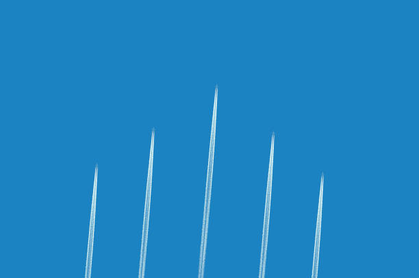 Five airplanes leaving white contrails in the clear blue sky. Copy space.