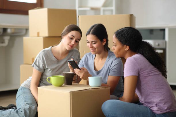istock Three roommates checking cell phone moving home 2173893919