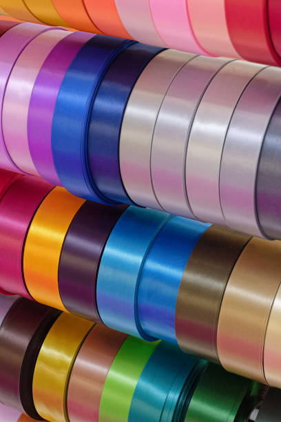 Rolls of multi-coloured decorative ribbons, abstract textile industry background