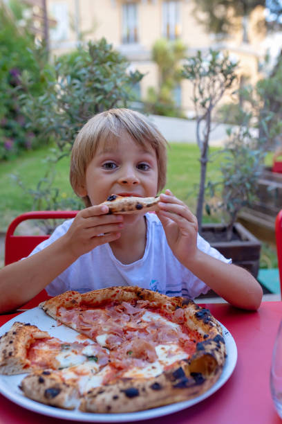 istock Child, eating pizza and burger in restaurant, summertime 2173907270
