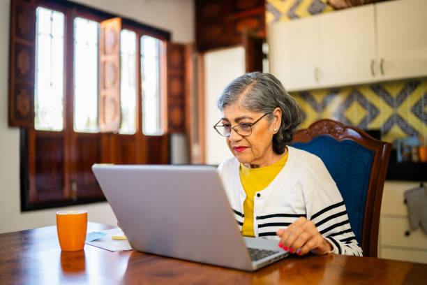 istock Senior woman doing home finances using laptop at home 2173908479