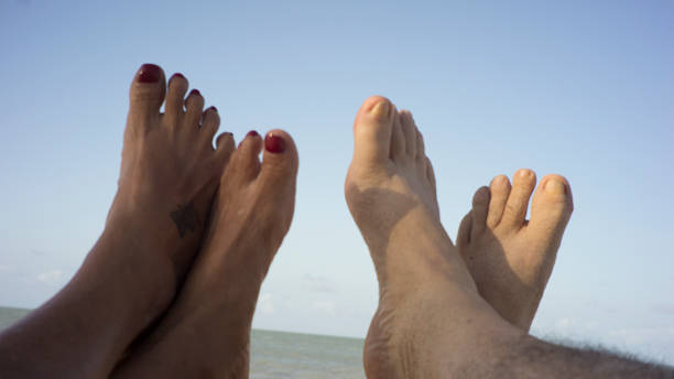 human feet sunbathing on the beach