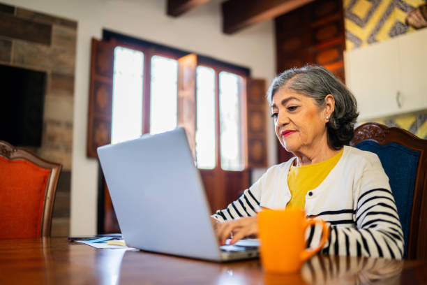istock Senior woman doing home finances using laptop at home 2173908944
