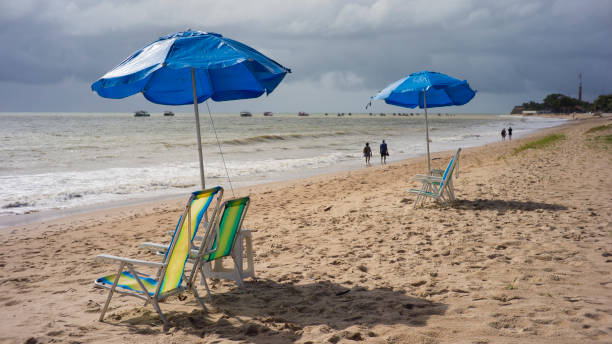 istock beach scene, waterfront with chairs and umbrella 2173908954