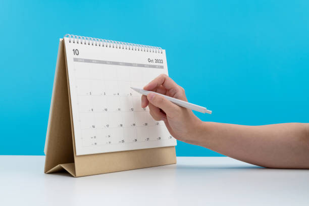 istock Woman hand with pen writing on calendar page 2173910288