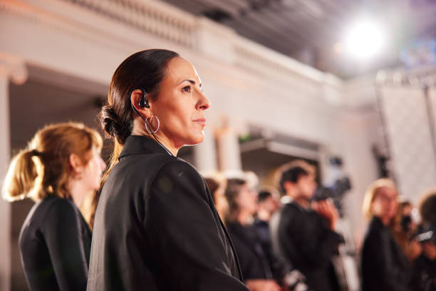 The security agent stands focused and ready as the politician arrives, ensuring everything is in order.
