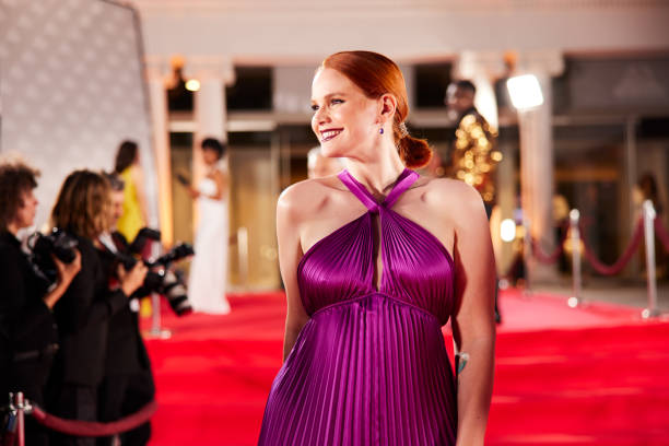 The actress pauses on the red carpet, striking a pose for the paparazzi while offering a warm smile.