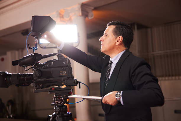 istock Wearing a suit, the focused camera operator expertly manages the streaming equipment, ensuring flawless event coverage. 2173911800