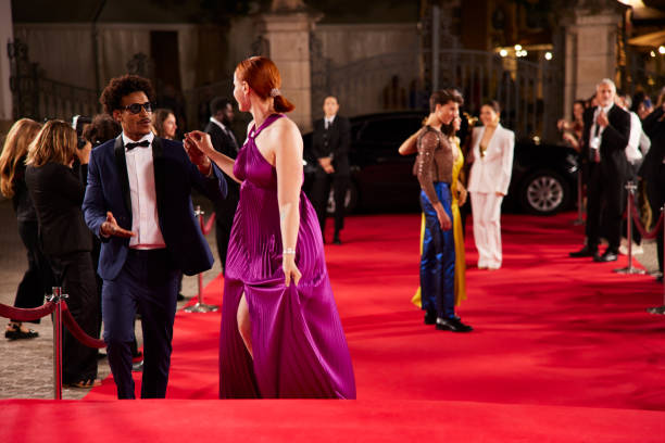 istock Leading actor supports the actress as she climbs the red carpet steps. 2173911982