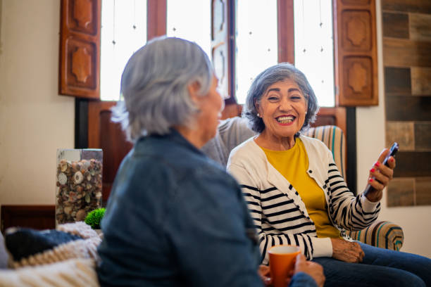 istock Senior friends talking and using mobile phone at home 2173912479