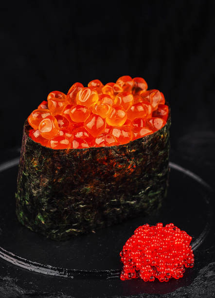 istock Gunkan maki sushi with tobiko flying fish roe on black stone 2173916059