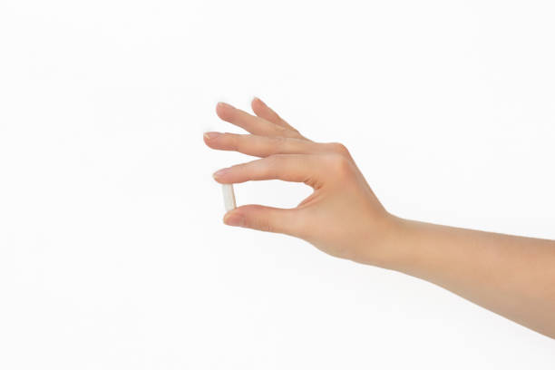 istock White pill in female hand on white background, Taking Your Medication 2173916467