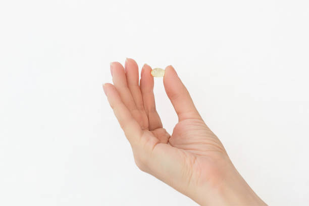 istock capsule in female hand on white background 2173916503